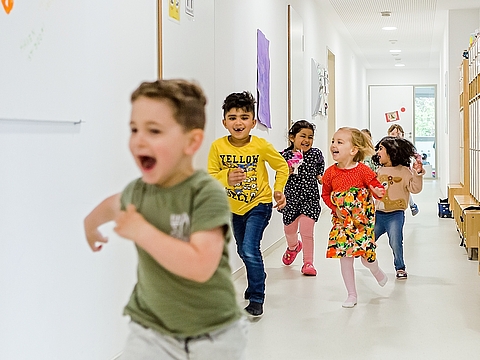 Alle sind dabei: Kinder rennen im Flur im FRÖBEL-Kindergarten Landsberger Straße, Münster
